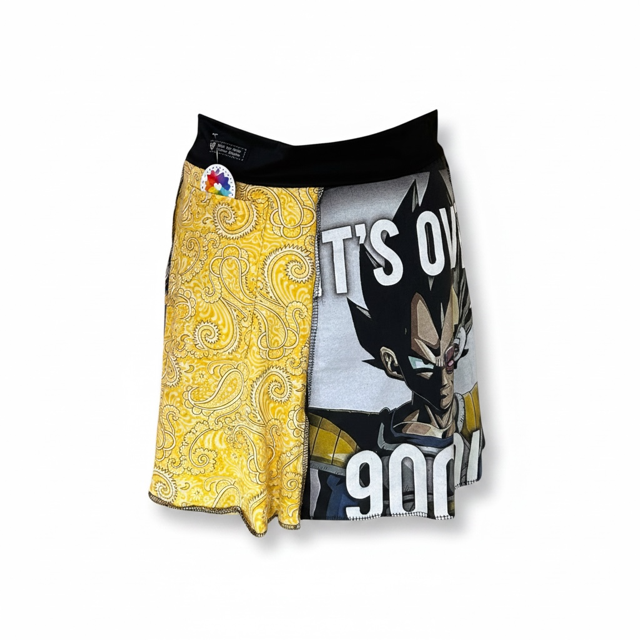 Women's skirt featuring a split design: one side has a yellow paisley pattern, and the other side has a graphic print of Vegeta from Dragon Ball Z with the text 'IT'S OVER 9000'. The shorts have a black waistband and are shown against a plain white background.